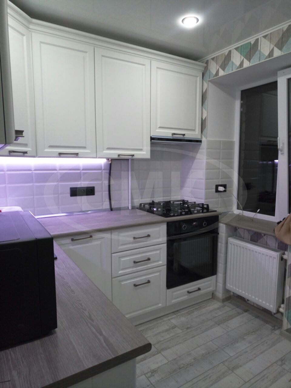 Угловая кухня на заказ с подсветкой, карниз и фасады выполнены с пленкой ПВЗ из плиты МДФ.